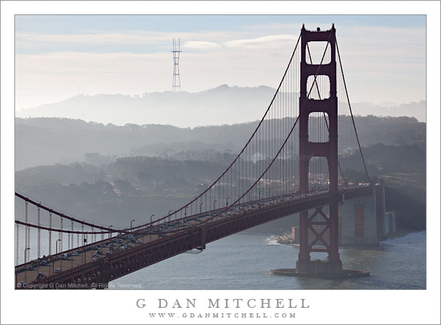 Sutro Tower and Golden Gate Bridge South Tower, Morning - Morning traffic crosses the Golden Gate Bridge approaching the south tower with haze-shrouded San Francisco hills and Sutro Tower beyond.