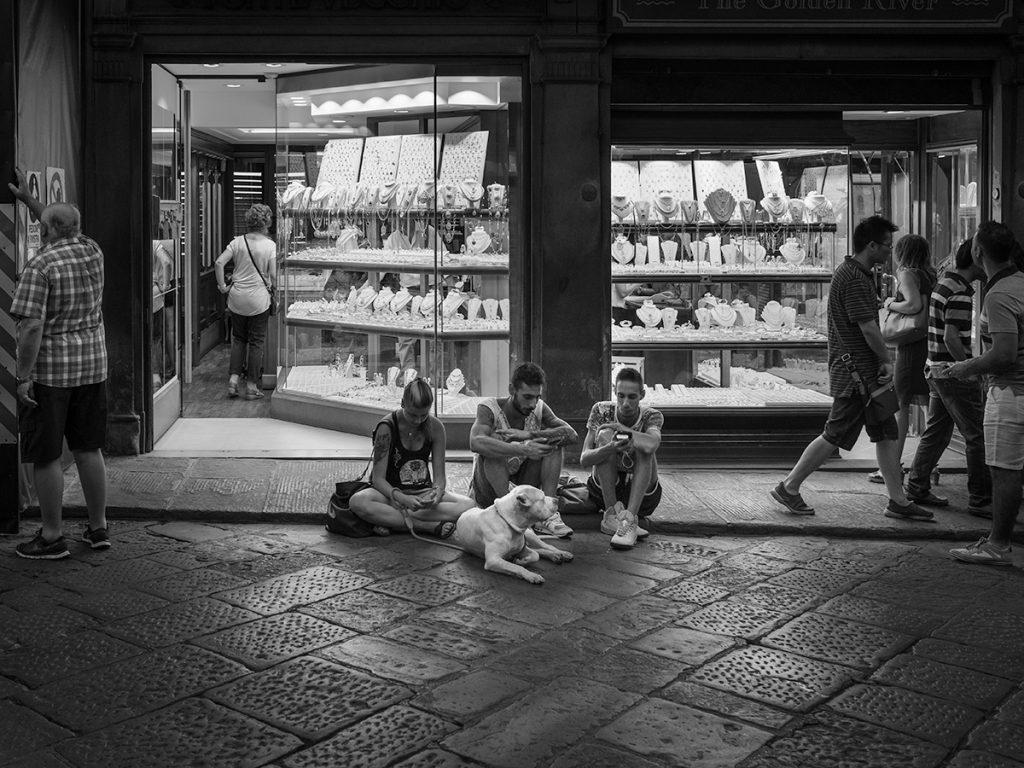 Seated People, Dog — Seated people with a white dog in front of Florence shops on the Ponte Vecchio.