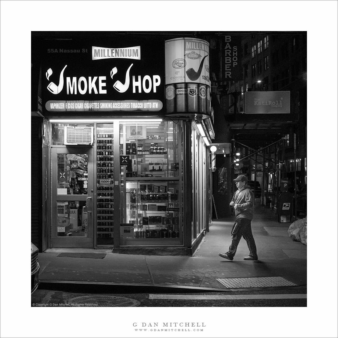 “Smoke Shop” — Night photograph of a man approaching the Millennium Smoke Shop in Lower Manhattan.